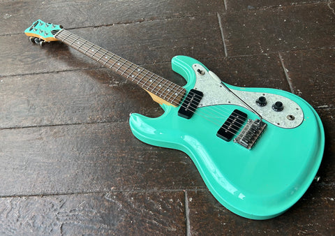 Surf green Aria Diamond DM-380 electric guitar with black pick-ups and rosewood fretboard and surf green headstock