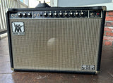 Musicman blacktolxet, black control panel with black and silver knobs, musicman silver badge logo, with grey grill clloth